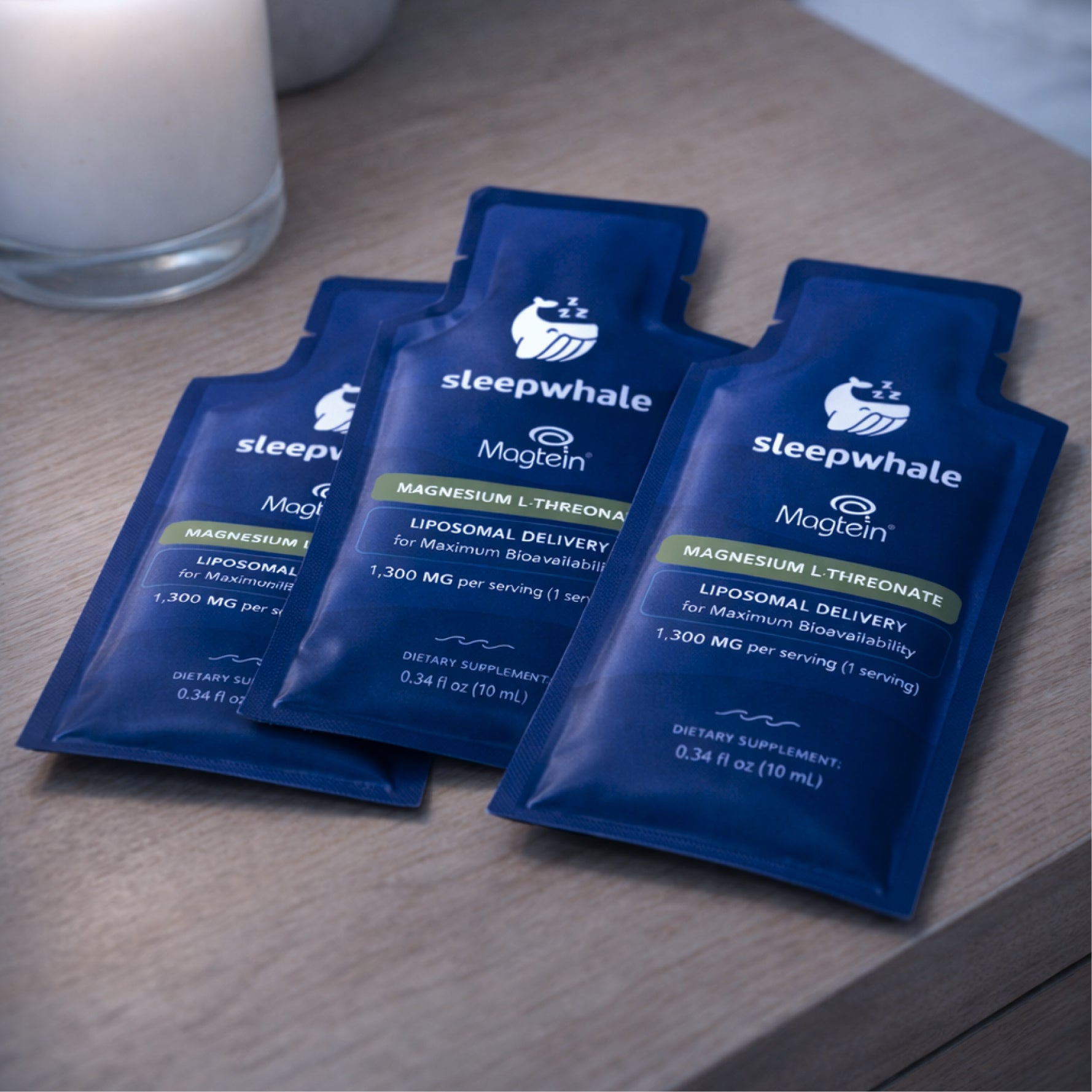 Three blue packets of Magtein on a wooden surface.